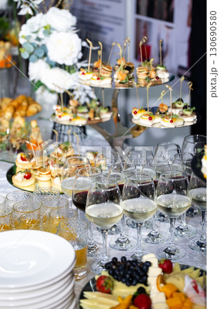 Buffet table with wine glasses, canapes and fruit plate at celebration 130690580