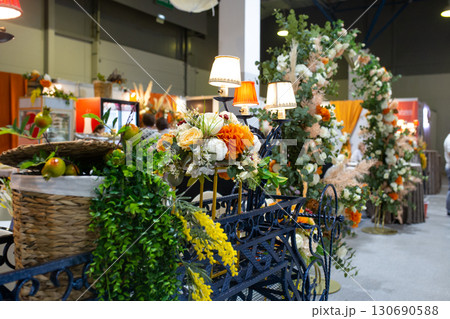 Decorative cart with lamps, flowers and greenery in interior design 130690588