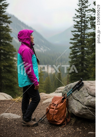 Solo Hiker Gazing at a Mountain Valley View from a Misty Pine Forest Trail 130690629