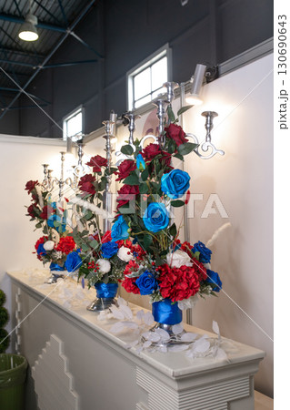 Elegant floral arrangements in red, white, and blue with silver candelabras.  130690643
