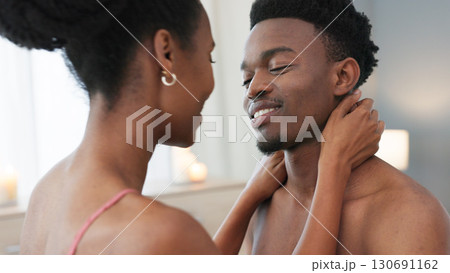 Happy, black couple and intimacy in bedroom in the morning for love, romance and passion at house or home. Young, man and woman with smile and bonding together or touch on a weekend with quality time 130691162