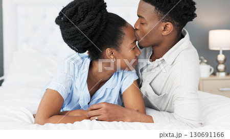 Love, morning or black couple kiss in bedroom for bond, support or trust in a marriage commitment. Hug, forehead and African man with a a woman, care or understanding in a house, hotel or apartment Love, morning or black couple kiss in bedroom for bond, support or trust in a marriage commitment. Hug, forehead and African man with a a woman, care or understanding in a house, hotel or apartment 130691166