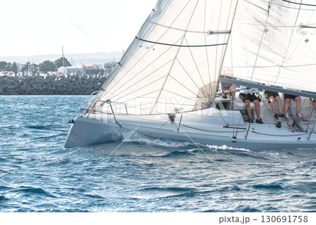 Sailing yacht competing in a regatta, cutting through the waves 130691758
