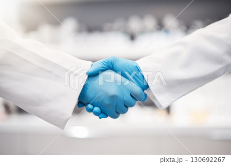 Doctor, handshake and gloves for healthcare, partnership or trust for collaboration, unity or lab support at. Team of medical experts shaking hands in teamwork for agreement or research success 130692267