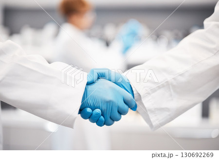 Doctor, shaking hands and gloves for safety in healthcare, partnership or trust for collaboration, unity or support at lab. Team of medical experts handshake in teamwork for agreement or success Doctor, shaking hands and gloves for safety in healthcare, partnership or trust for collaboration, unity or support at lab. Team of medical experts handshake in teamwork for agreement or success 130692269