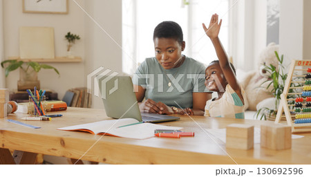 Child raise hand for elearning on laptop for knowledge video call for development at home. Technology, online class and black woman helping boy kid with homework on computer in dining room at a house 130692596