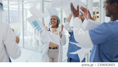 Doctors, team and throw paper in hospital for success, win and celebration with solidarity, support or diversity. Men, women and applause for confetti, goals and medical results with smile in clinic 130692603