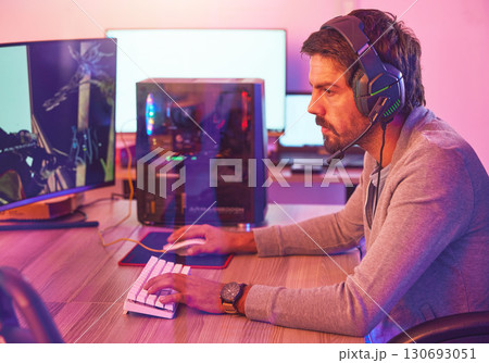 Computer gamer, man and headphones for esports, online games and virtual competition in dark room. Gaming guy, rpg player and video game on headset in neon lighting, pc technology and cyber internet 130693051