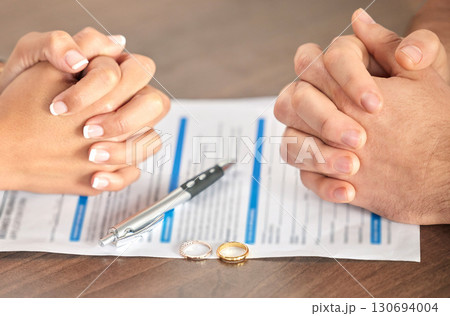 Divorce, signing and hands of a couple with a document for court, deal and legal paperwork. Together, conflict and married man and woman with an agreement, paperwork and form to end a marriage Divorce, signing and hands of a couple with a document for court, deal and legal paperwork. Together, conflict and married man and woman with an agreement, paperwork and form to end a marriage 130694004
