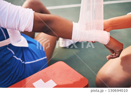Sport injury, bandage and first aid with wrist pain and help, health and medic, accident and people on netball court. Medical emergency, train and sports, fitness and arm, anatomy and muscle sprain 130694010