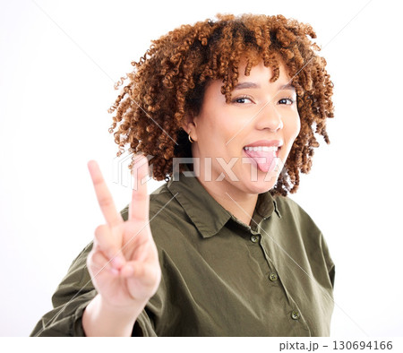 Peace, sign and portrait of black woman with tongue out excited, confident and happy isolated against a studio white background. Young, fun and hand gesture by female feeling relax and happiness Peace, sign and portrait of black woman with tongue out excited, confident and happy isolated against a studio white background. Young, fun and hand gesture by female feeling relax and happiness 130694166