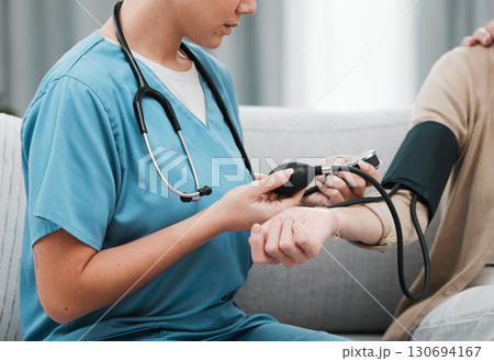 Blood pressure, caregiver nurse and woman patient on a nursing home for health and wellness check. Healthcare, doctor and living room consultation for medical test in retirement on a lounge couch Blood pressure, caregiver nurse and woman patient on a nursing home for health and wellness check. Healthcare, doctor and living room consultation for medical test in retirement on a lounge couch 130694167