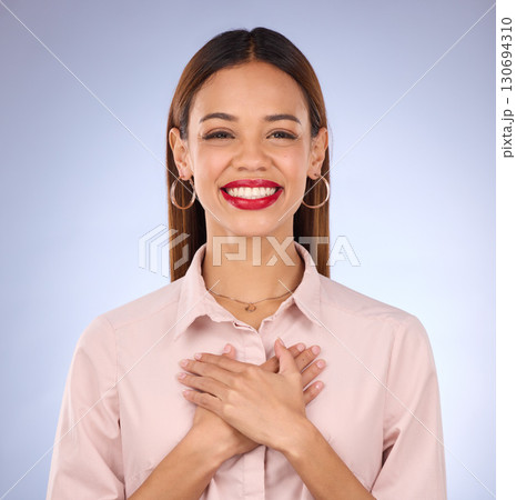 Hands on chest, heart and healthcare, woman against studio background and content, healthy and cardiology. Wellness, portrait and gratitude, cardiovascular health with female, happy with self love 130694310