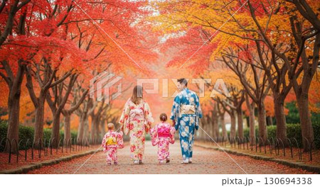 紅葉の並木道を和装で散歩する外国人家族の後ろ姿 130694338