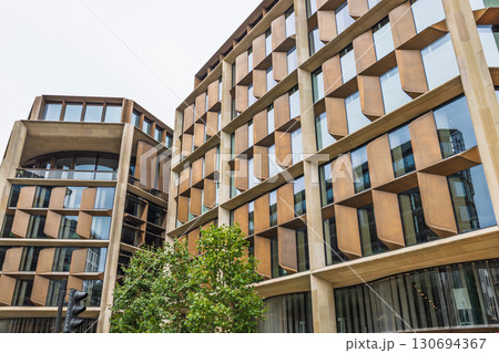 Low angle view of sustainable city architecture with patterned windows and geometry Low angle view of sustainable city architecture with patterned windows and geometry 130694367