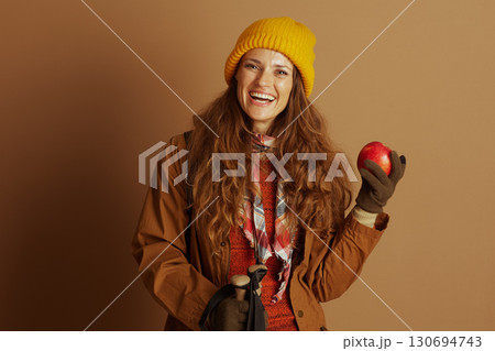 Cheerful Woman Hiker with Apple and Poles 130694743