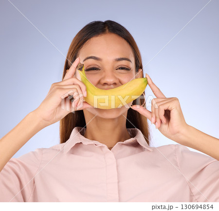 Woman, banana and smile portrait in studio for healthy food, vegan diet and fruit in hands. Face of a happy black person model with fruits for health, wellness and nutrition on purple background 130694854