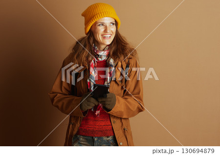 Content Woman in Warm Gear Using Smartphone 130694879