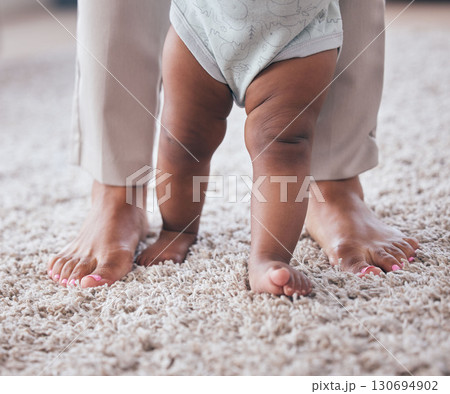 Baby feet, youth walking and kid learning with mother in living room lounge with mobility development. Floor, home and first steps of a young child with mama love, care and support in a house Baby feet, youth walking and kid learning with mother in living room lounge with mobility development. Floor, home and first steps of a young child with mama love, care and support in a house 130694902