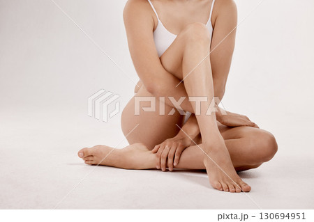Skincare, cosmetics and legs of a woman for beauty isolated on a white background in a studio. Spa, dermatology and calm model with body wellness, care and hygiene in underwear on a backdrop 130694951