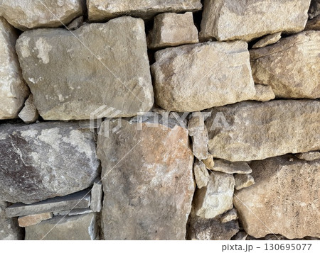 Stone wall photo, textured background. Close-up of a rustic stone wall. Stone wall photo, textured background. Close-up of a rustic stone wall. 130695077
