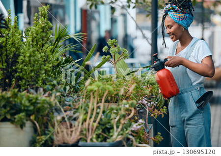 Water, flowers or black woman gardening in small business shop for healthy leaf or organic plants growth. Irrigation, store manager or girl entrepreneur watering floral agriculture with a happy smile Water, flowers or black woman gardening in small business shop for healthy leaf or organic plants growth. Irrigation, store manager or girl entrepreneur watering floral agriculture with a happy smile 130695120