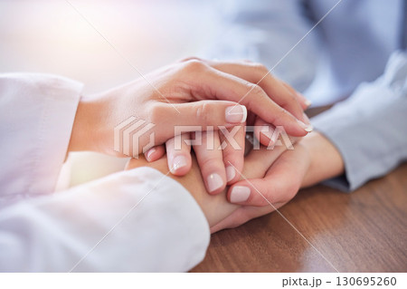 Holding hands, doctor and patient at desk for comfort, talking and communication for bad news, mental health or support. Therapist woman, cancer and together for empathy, care or wellness in hospital Holding hands, doctor and patient at desk for comfort, talking and communication for bad news, mental health or support. Therapist woman, cancer and together for empathy, care or wellness in hospital 130695260