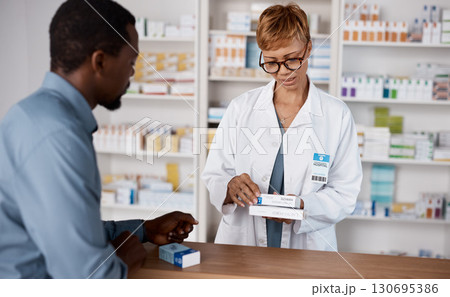 Pharmacist woman, medicine and healthcare with customer while reading information on pills box. Black man with pharmacy, clinic or store worker for pharmaceutical, medical and health counter service Pharmacist woman, medicine and healthcare with customer while reading information on pills box. Black man with pharmacy, clinic or store worker for pharmaceutical, medical and health counter service 130695386