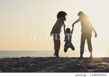 Silhouette, mock up and a family on a beach, playing while having fun together by the ocean or sea. Kids, travel or love with a mother, father and child on the sand at the coast to play while bonding 130695650