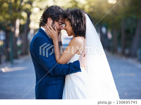 Wedding, couple and love outdoor for marriage celebration event together with commitment. Happy interracial man and woman at park with trust, partnership and smile while touching face with care 130695745