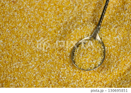 Raw Yellow Corn Grits in a Spoon 130695851