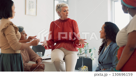 Creative senior woman, coaching and meeting in leadership, collaboration or strategy together at office. Mature female person talking to employees in staff training, workshop or startup at workplace Creative senior woman, coaching and meeting in leadership, collaboration or strategy together at office. Mature female person talking to employees in staff training, workshop or startup at workplace 130696159