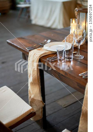 Burlap path on the table. The simple style of our ancestors. Historical table setting. White plate. Burlap path on the table. The simple style of our ancestors. Historical table setting. White plate. 130697184