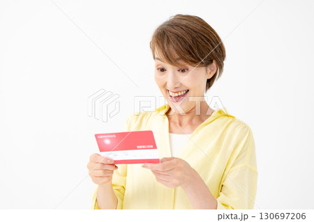 通帳を見て喜ぶミドル女性 通帳を見て喜ぶミドル女性 130697206