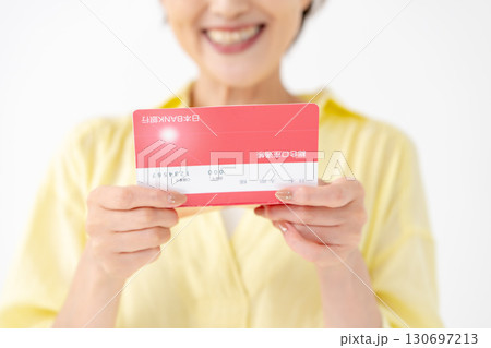 通帳を見て喜ぶミドル女性 手元 通帳を見て喜ぶミドル女性 手元 130697213