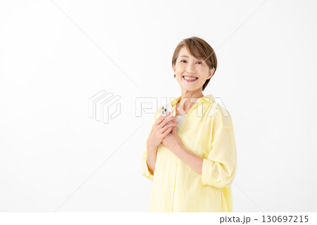 笑顔でスマートフォンを操作する女性 笑顔でスマートフォンを操作する女性 130697215