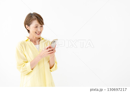 笑顔でスマートフォンを操作する女性 130697217