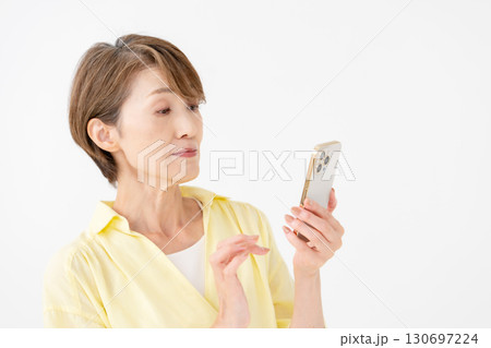 スマートフォンを操作する女性　悩む 130697224