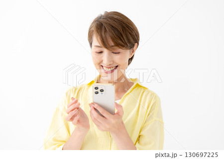 笑顔でスマートフォンを操作する女性 笑顔でスマートフォンを操作する女性 130697225