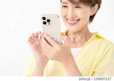 笑顔でスマートフォンを操作する女性 130697227