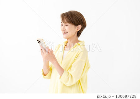 笑顔でスマートフォンを操作する女性 130697229