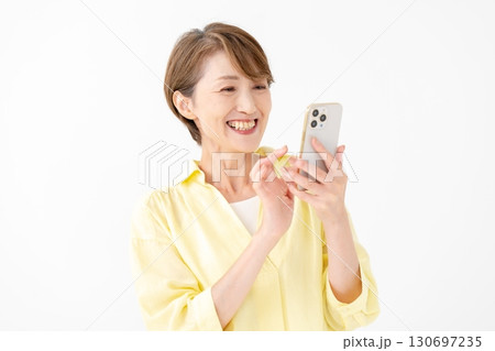 笑顔でスマートフォンを操作する女性 130697235