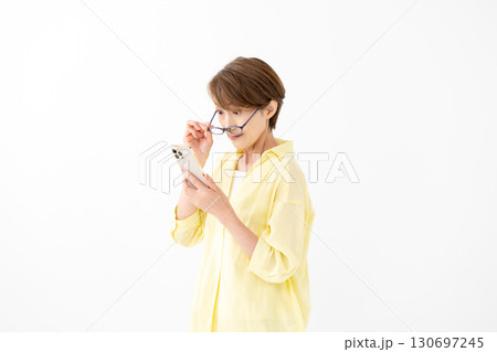 老眼鏡でスマホを見る女性 130697245