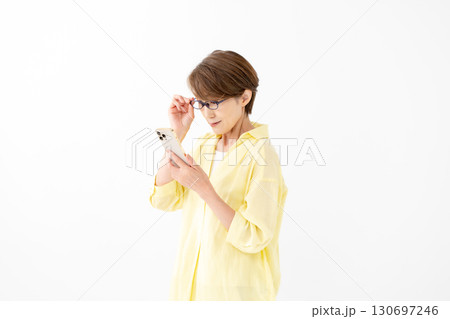 老眼鏡でスマホを見る女性 130697246