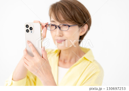 老眼鏡でスマホを見る女性 老眼鏡でスマホを見る女性 130697253