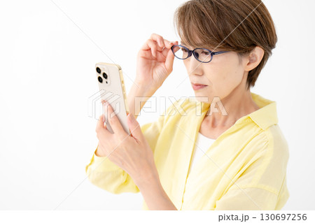 老眼鏡でスマホを見る女性 130697256