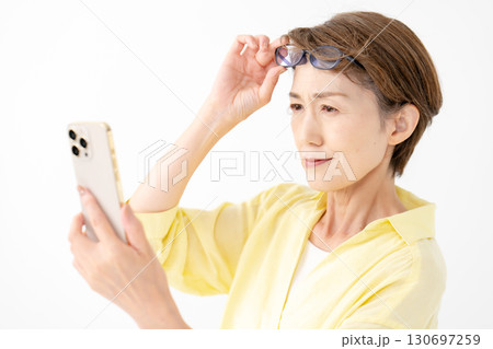 老眼鏡でスマホを見る女性 130697259