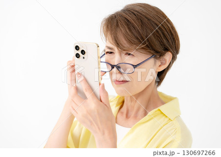 老眼鏡でスマホを見る女性 130697266