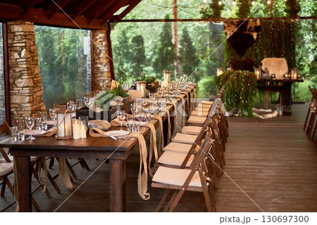 A large terrace for a wedding and banquet in a rustic style. Thrones and skins. Stylized as Vikings. Dark wood. A lot of greenery. A large terrace for a wedding and banquet in a rustic style. Thrones and skins. Stylized as Vikings. Dark wood. A lot of greenery. 130697300