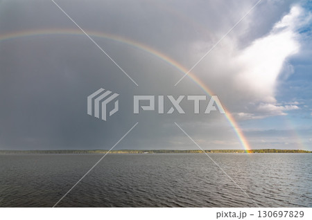 Rainbow over Blue lake with cloudy sky 130697829